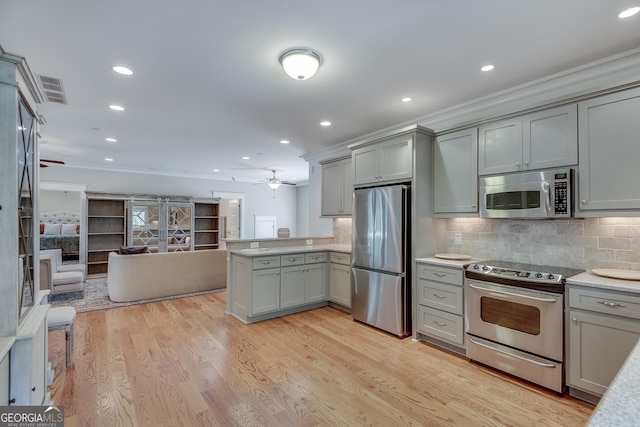 114 Trinity Hollow Dr, Canton, GA 30115 - kitchen with stainless steel appliances, gray cabinetry, a peninsula, ornamental molding, and open floor plan