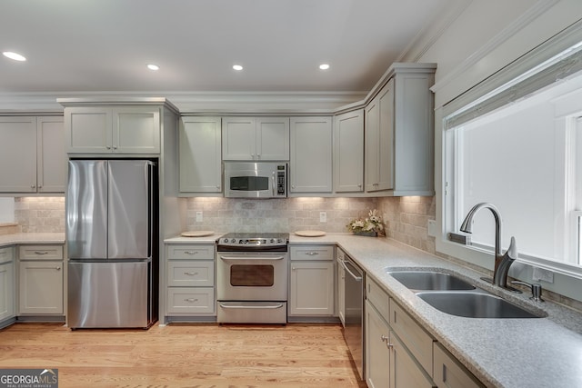 114 Trinity Hollow Dr, Canton, GA 30115 - kitchen featuring stainless steel appliances, a sink, gray cabinets, backsplash, and light wood-style floors