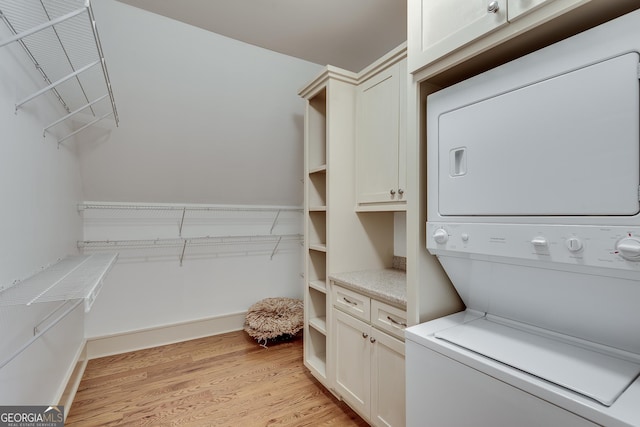 114 Trinity Hollow Dr, Canton, GA 30115 - laundry room with stacked washing machine and dryer, cabinet space, and light wood-style floors