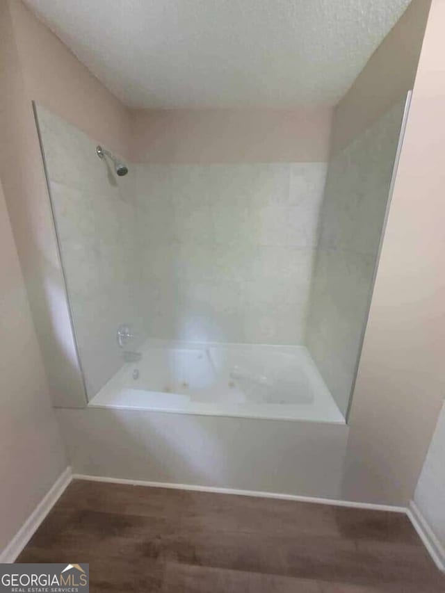 147 Katie Ln, Carrollton, GA 30117 - full bath with wood finished floors, bathing tub / shower combination, and baseboards
