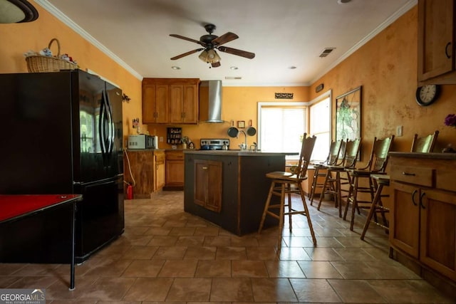 1079 Hardeman Farm Rd, Carnesville, GA 30521 - kitchen featuring freestanding refrigerator, wall chimney range hood, a ceiling fan, ornamental molding, and brown cabinetry