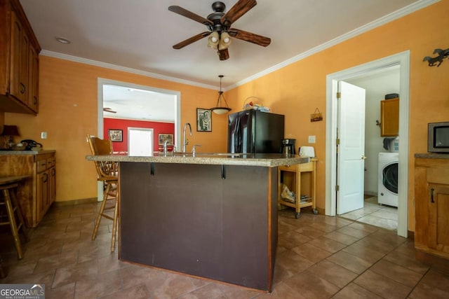 1079 Hardeman Farm Rd, Carnesville, GA 30521 - kitchen with washer / clothes dryer, freestanding refrigerator, a kitchen bar, ceiling fan, and stainless steel microwave