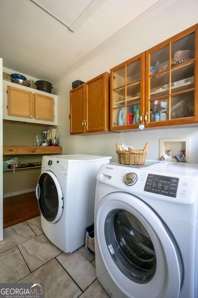 1079 Hardeman Farm Rd, Carnesville, GA 30521 - laundry room with cabinet space, washer and dryer, light tile patterned floors, and crown molding