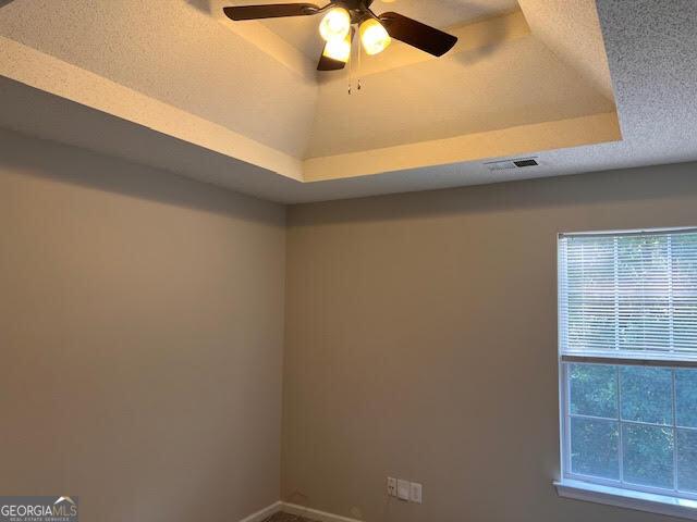 149 Titan Rd, Stockbridge, GA 30281 - detailed view of ceiling fan, baseboards, and a tray ceiling