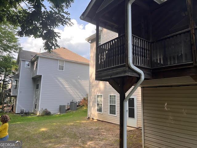 149 Titan Rd, Stockbridge, GA 30281 - rear view of property with a balcony, a lawn, and central AC