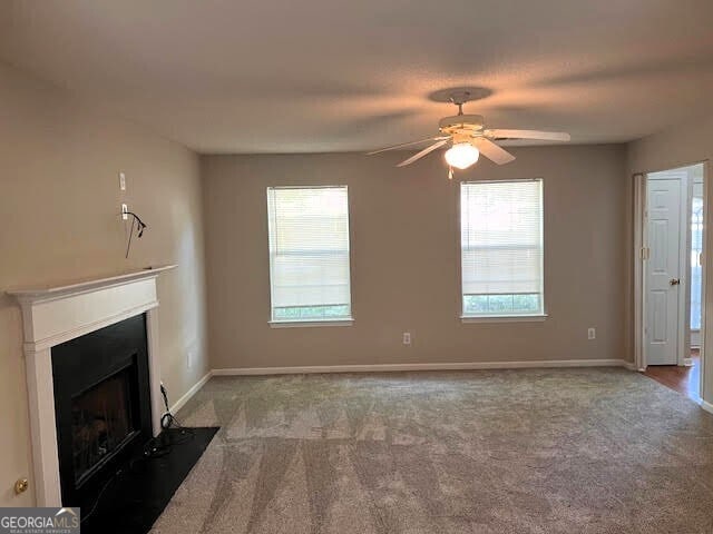 149 Titan Rd, Stockbridge, GA 30281 - unfurnished living room featuring ceiling fan, carpet, plenty of natural light, and a fireplace