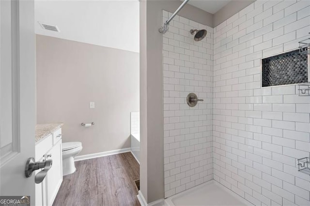 76 Vaughn NE, Cartersville, GA 30121 - bathroom featuring wood finished floors, tiled shower, toilet, and vanity