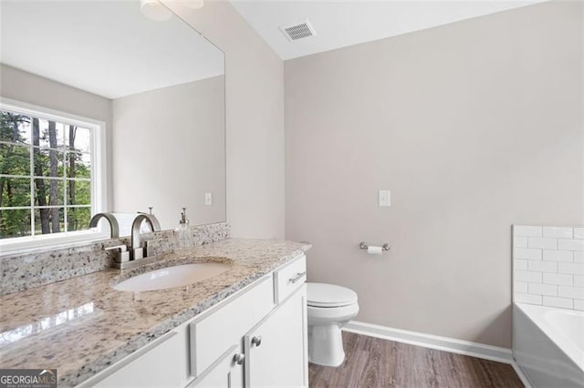 76 Vaughn NE, Cartersville, GA 30121 - full bath with vanity, a tub to relax in, toilet, wood finished floors, and baseboards