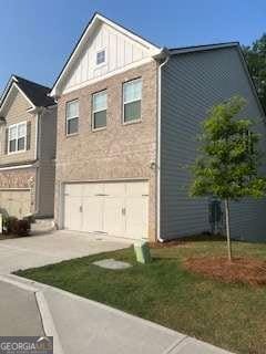 7695 Baron Rd, Fairburn, GA 30213 - view of home's exterior featuring driveway, an attached garage, and board and batten siding