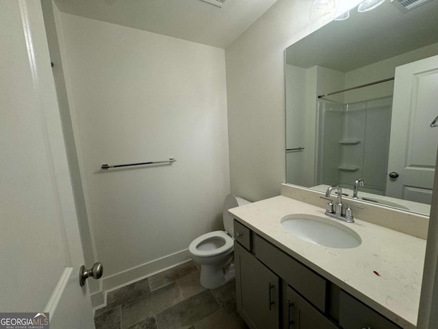 7695 Baron Rd, Fairburn, GA 30213 - full bathroom featuring toilet, vanity, a shower, baseboards, and stone finish flooring