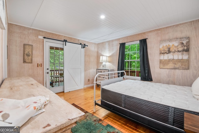 254 Rue Ln, Clayton, GA 30525 - bedroom featuring access to exterior, a barn door, wood finished floors, and wood walls