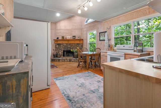 254 Rue Ln, Clayton, GA 30525 - kitchen with white appliances, light wood-style floors, a stone fireplace, lofted ceiling, and light countertops
