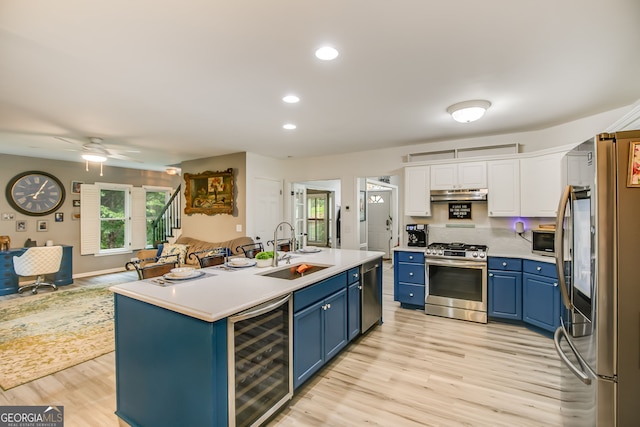 41 Wexford Cir, Cartersville, GA 30121 - kitchen with stainless steel appliances, wine cooler, blue cabinetry, under cabinet range hood, and recessed lighting