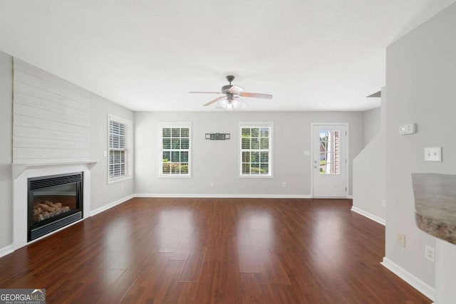 174 Randall Dr, Rockmart, GA 30153 - unfurnished living room featuring ceiling fan, wood finished floors, a glass covered fireplace, and baseboards