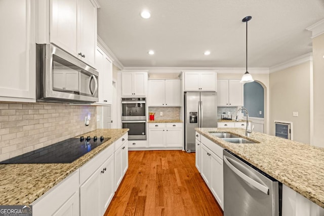 86 Crestview Dr, Guyton, GA 31312 - kitchen featuring stainless steel appliances, a sink, white cabinets, ornamental molding, and light wood finished floors