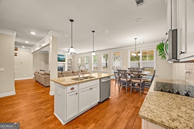 86 Crestview Dr, Guyton, GA 31312 - kitchen featuring a sink, a glass covered fireplace, appliances with stainless steel finishes, crown molding, and white cabinetry