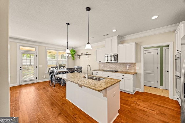 86 Crestview Dr, Guyton, GA 31312 - kitchen with a sink, stainless steel microwave, crown molding, black electric cooktop, and a kitchen bar