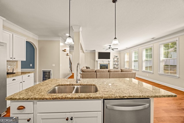 86 Crestview Dr, Guyton, GA 31312 - kitchen featuring appliances with stainless steel finishes, a sink, ornamental molding, wood finished floors, and a glass covered fireplace