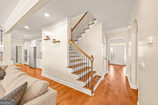 86 Crestview Dr, Guyton, GA 31312 - entryway with crown molding, arched walkways, light wood-type flooring, stairs, and baseboards