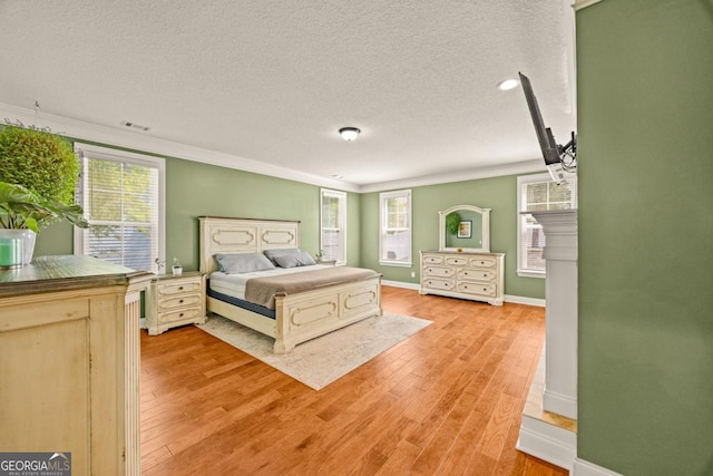 86 Crestview Dr, Guyton, GA 31312 - bedroom featuring a textured ceiling, light wood-type flooring, multiple windows, ornamental molding, and baseboards