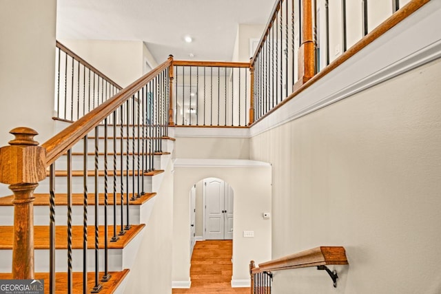 86 Crestview Dr, Guyton, GA 31312 - stairs featuring arched walkways, a towering ceiling, wood finished floors, and recessed lighting