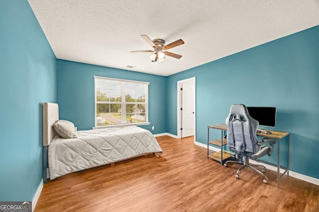 86 Crestview Dr, Guyton, GA 31312 - bedroom with baseboards, wood finished floors, a textured ceiling, ceiling fan, and a desk