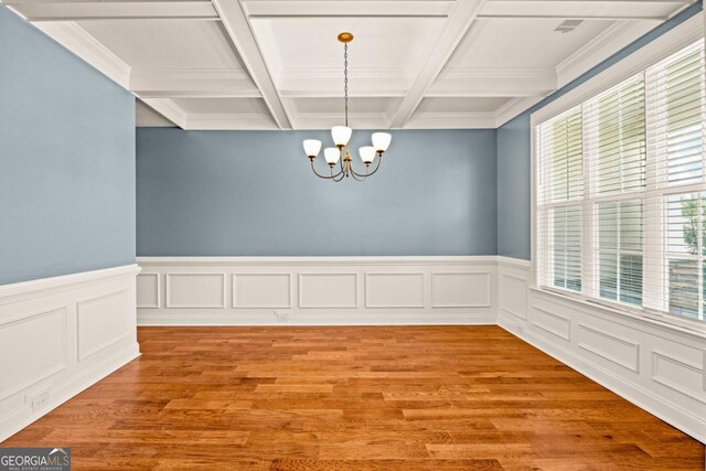86 Crestview Dr, Guyton, GA 31312 - empty room with a chandelier, coffered ceiling, beam ceiling, light wood-style flooring, and wainscoting