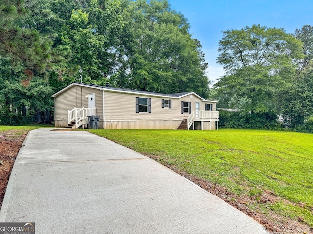 368 Hemlock Ln, Locust Grove, GA 30248 - manufactured / mobile home with driveway, a front lawn, stairs, view of wooded area, and a deck
