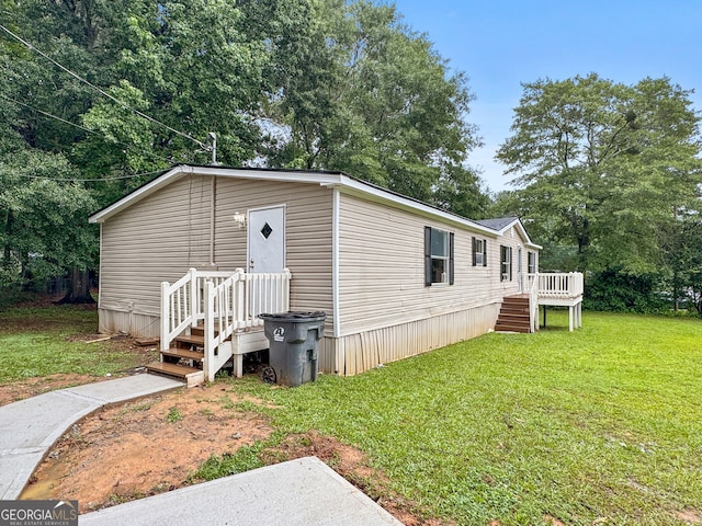 368 Hemlock Ln, Locust Grove, GA 30248 - view of front facade featuring a front lawn, a wooden deck, and stairs