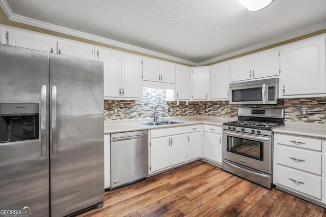 602 Pine Knoll Ct, Mcdonough, GA 30252 - kitchen featuring appliances with stainless steel finishes, a sink, light countertops, white cabinets, and crown molding