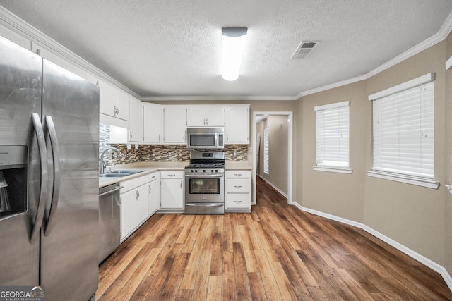 602 Pine Knoll Ct, Mcdonough, GA 30252 - kitchen with appliances with stainless steel finishes, a sink, light countertops, light wood-type flooring, and a textured ceiling