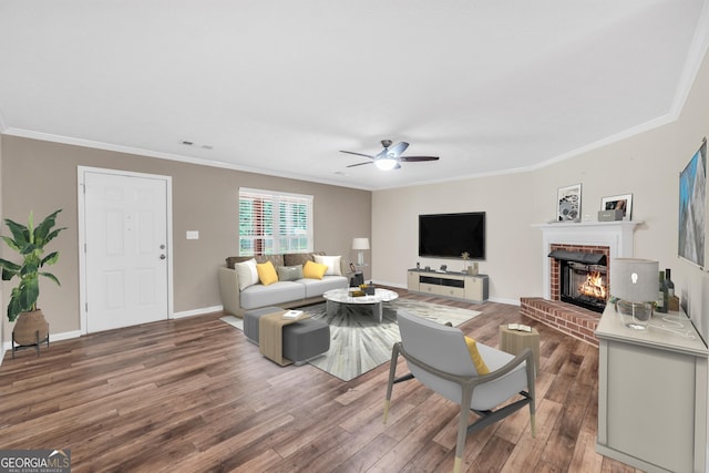 602 Pine Knoll Ct, Mcdonough, GA 30252 - living area with a brick fireplace, crown molding, ceiling fan, wood finished floors, and baseboards
