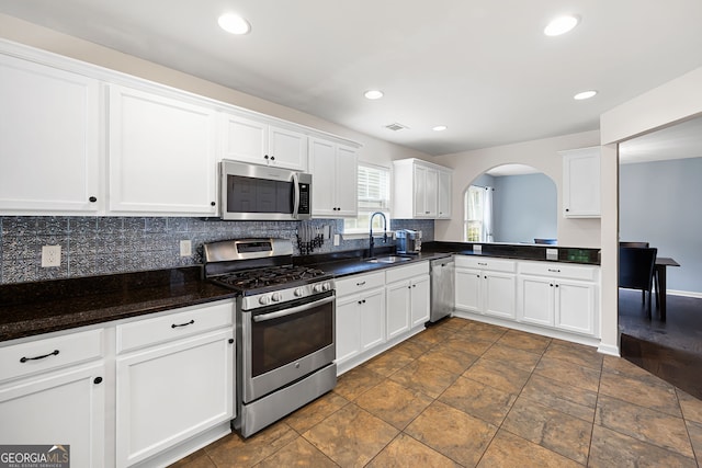 784 Crestworth Xing, Powder Springs, GA 30127 - kitchen with appliances with stainless steel finishes, arched walkways, decorative backsplash, white cabinets, and recessed lighting