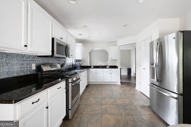 784 Crestworth Xing, Powder Springs, GA 30127 - kitchen featuring appliances with stainless steel finishes, tasteful backsplash, white cabinets, recessed lighting, and arched walkways
