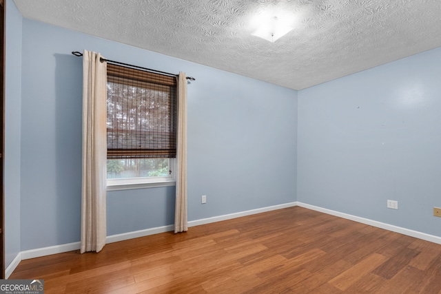 7972 Woods Ln, Jonesboro, GA 30236 - unfurnished room with wood finished floors, a textured ceiling, and baseboards