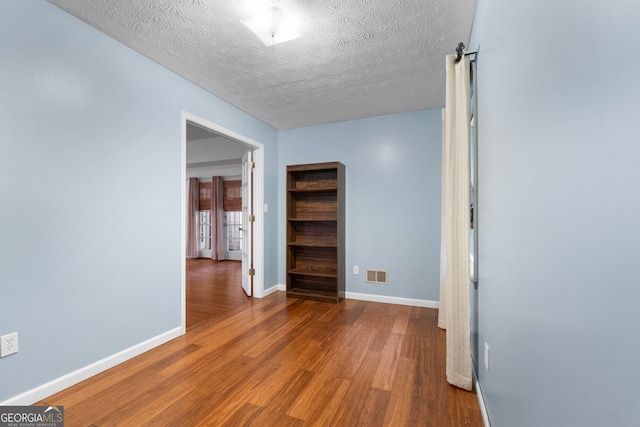 7972 Woods Ln, Jonesboro, GA 30236 - hallway with wood finished floors, baseboards, and a textured ceiling