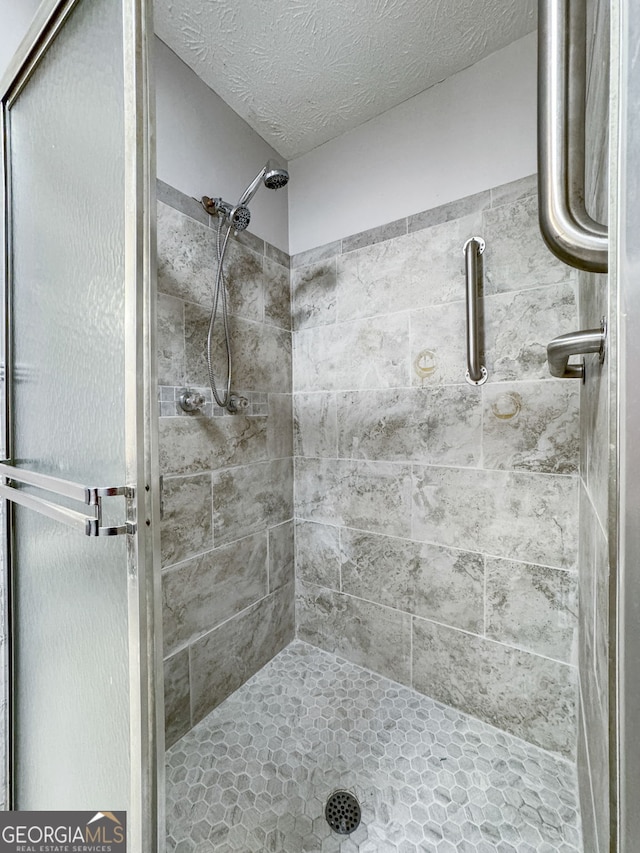 7972 Woods Ln, Jonesboro, GA 30236 - bathroom featuring a shower stall and a textured ceiling