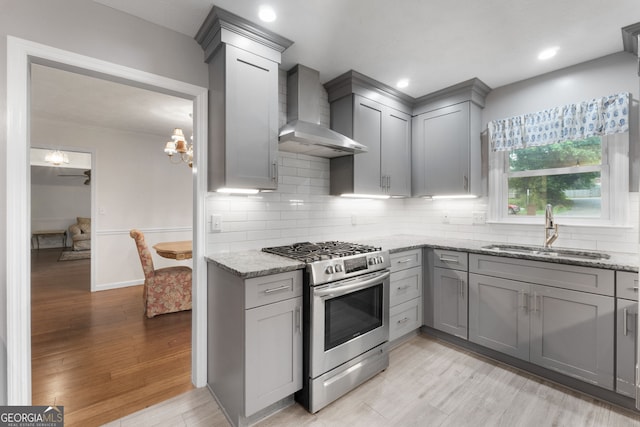7972 Woods Ln, Jonesboro, GA 30236 - kitchen with gas stove, gray cabinets, a sink, wall chimney exhaust hood, and light stone counters