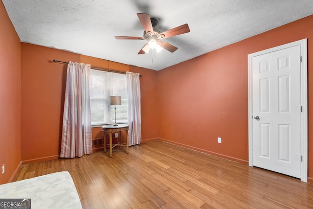7972 Woods Ln, Jonesboro, GA 30236 - bedroom featuring wood finished floors, baseboards, a textured ceiling, and ceiling fan
