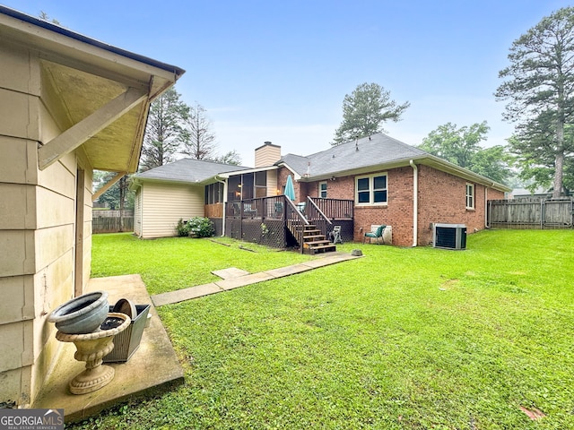 7972 Woods Ln, Jonesboro, GA 30236 - rear view of house featuring central AC, brick siding, a sunroom, a deck, and a chimney