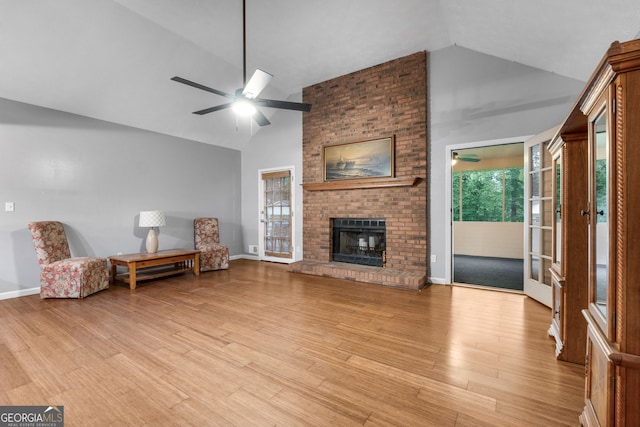 7972 Woods Ln, Jonesboro, GA 30236 - living area with light wood-type flooring, high vaulted ceiling, a ceiling fan, a brick fireplace, and baseboards