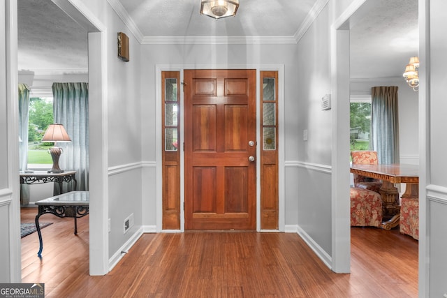 7972 Woods Ln, Jonesboro, GA 30236 - entrance foyer with wood finished floors, baseboards, a textured ceiling, and crown molding
