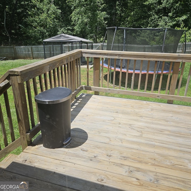 1649 Deer Creek Ln, Monroe, GA 30655 - deck featuring a trampoline, a fenced backyard, and view of scattered trees