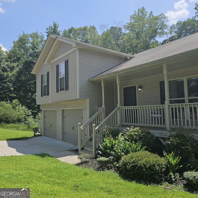 1649 Deer Creek Ln, Monroe, GA 30655 - split level home featuring covered porch, an attached garage, concrete driveway, board and batten siding, and a front lawn