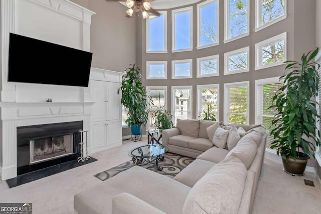 5810 Old Mill Trce, Lithonia, GA 30038 - living room featuring plenty of natural light, ceiling fan, a fireplace with flush hearth, a towering ceiling, and carpet flooring