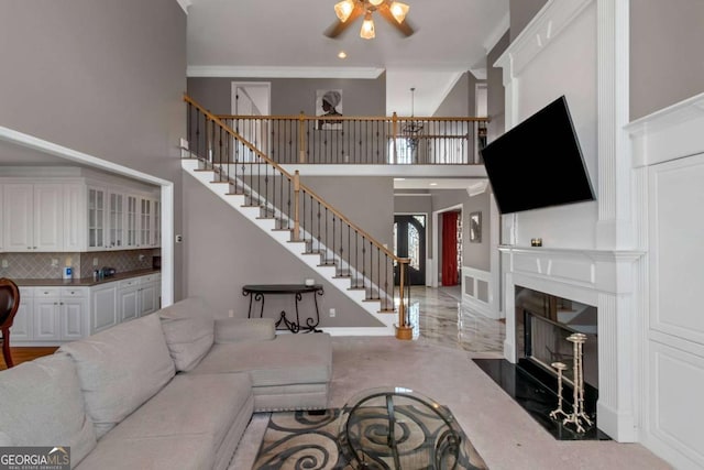 5810 Old Mill Trce, Lithonia, GA 30038 - living area with a ceiling fan, stairs, a towering ceiling, ornamental molding, and a fireplace with flush hearth