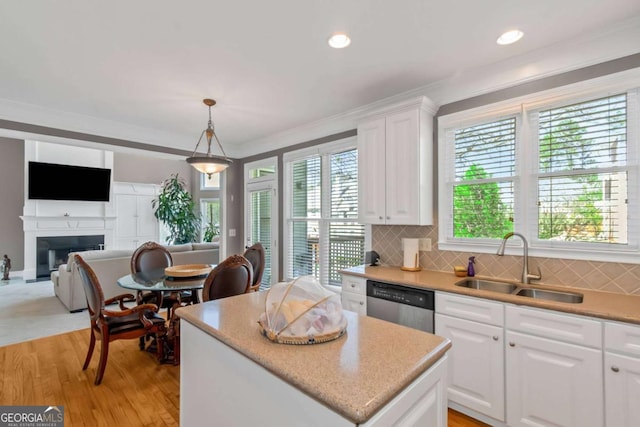 5810 Old Mill Trce, Lithonia, GA 30038 - kitchen featuring stainless steel dishwasher, a sink, a kitchen island, open floor plan, and a fireplace