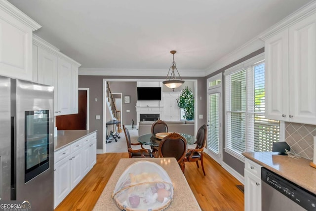 5810 Old Mill Trce, Lithonia, GA 30038 - kitchen featuring appliances with stainless steel finishes, light countertops, light wood-style floors, white cabinets, and crown molding