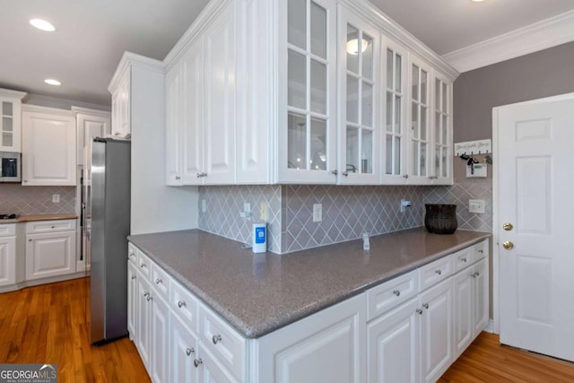 5810 Old Mill Trce, Lithonia, GA 30038 - kitchen featuring stainless steel appliances, white cabinetry, crown molding, wood finished floors, and backsplash