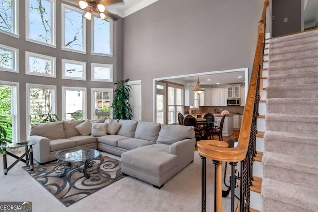 5810 Old Mill Trce, Lithonia, GA 30038 - living room with a towering ceiling, a ceiling fan, light carpet, stairway, and crown molding